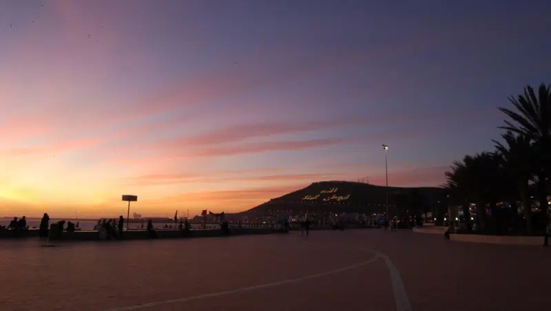 Der Sonnenuntergang in Agadir ist romantisch. Die Inschrift des Berges wird bei Nacht beleuchtet.
